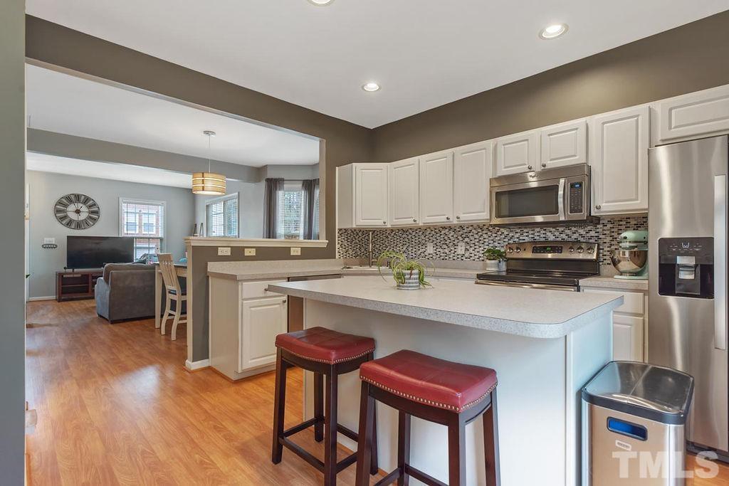 4711 Longhill Lane Raleigh, NC 27612 - Photo 10 of 27 a kitchen with table chairs refrigerator and cabinets