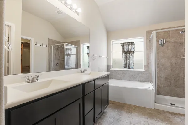 a bathroom with a tub a sink and mirror