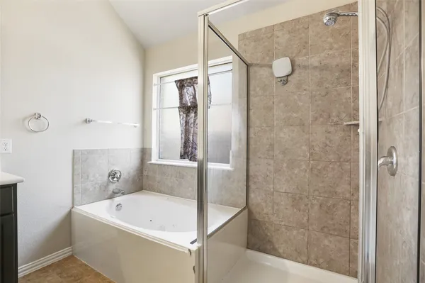 a bathroom with a white bath tub sitting next to a white sink and glass door