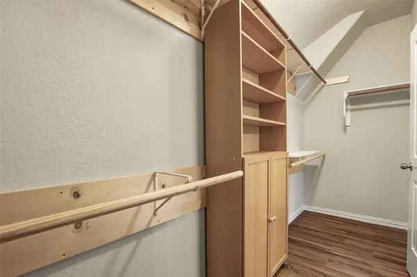 a view of walk in closet with empty racks