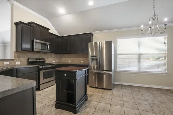 a kitchen with granite countertop a refrigerator stove and microwave