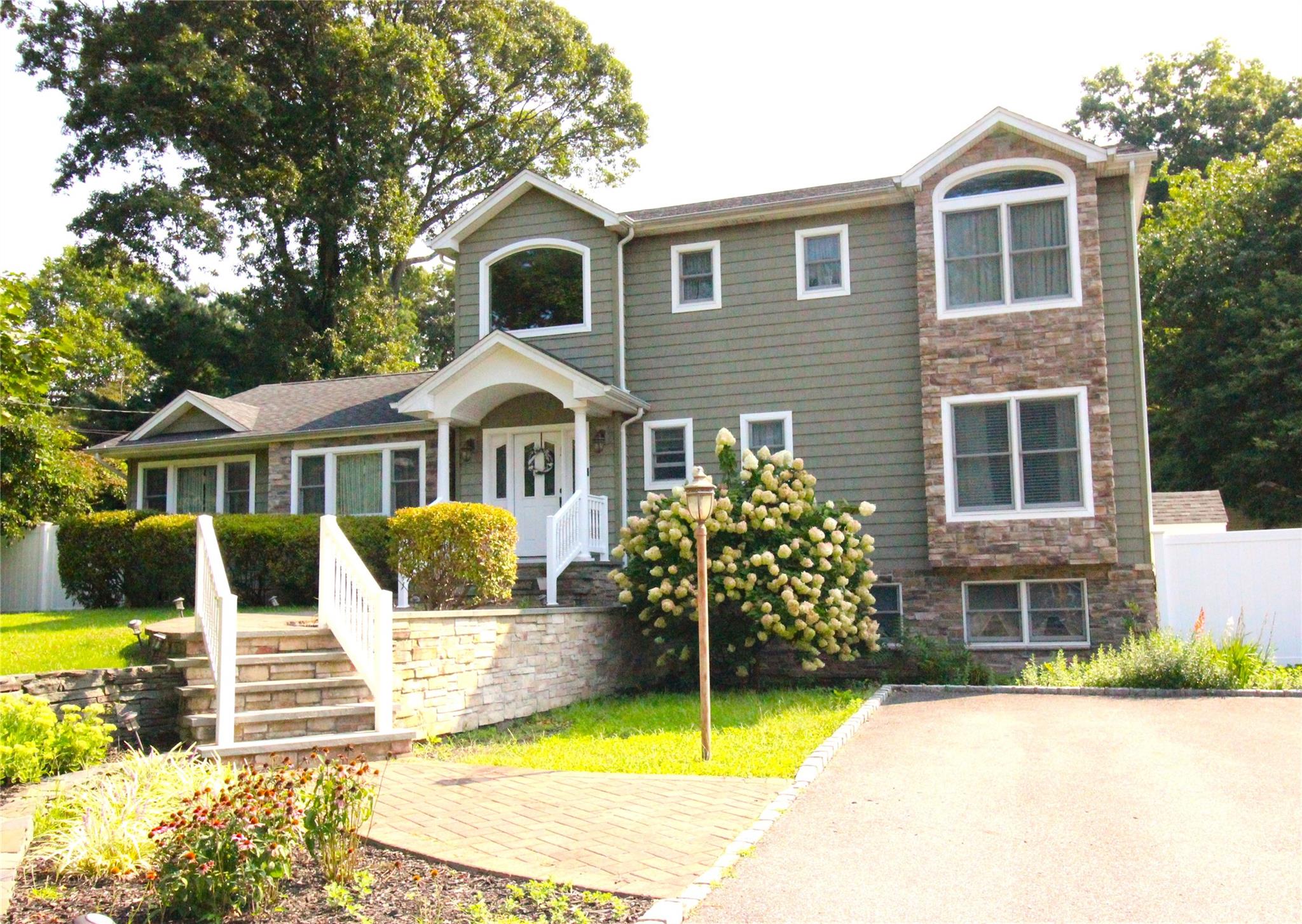 View of front of property with fence and stone siding