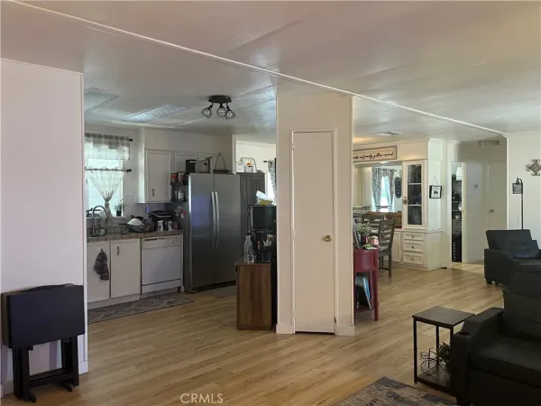 a kitchen with a refrigerator a dining table and chairs