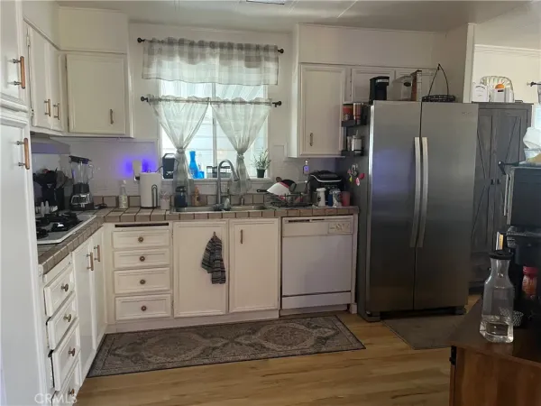 a kitchen with stainless steel appliances a sink cabinets and a window