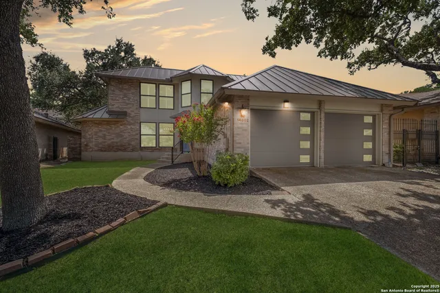 a front view of a house with a garden and yard
