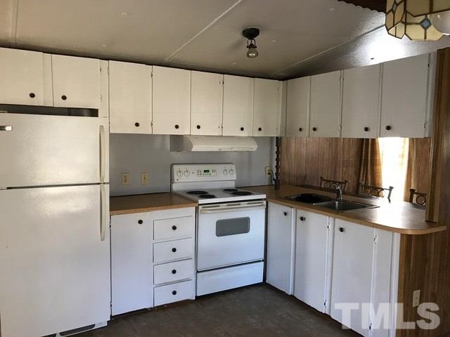 2017 Wiley Road Spring Hope, NC 27882 - Photo 5 of 23 a kitchen with granite countertop a white refrigerator oven a sink and white cabinets