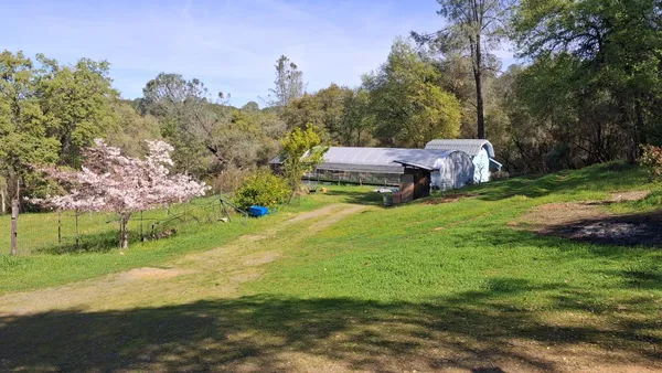 a backyard of a house with barbeque oven table and chairs