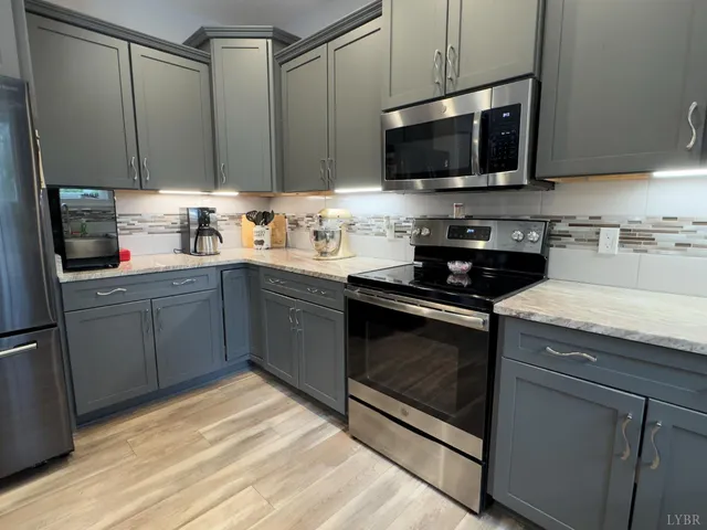 a kitchen with stainless steel appliances kitchen island granite countertop a sink stove and microwave