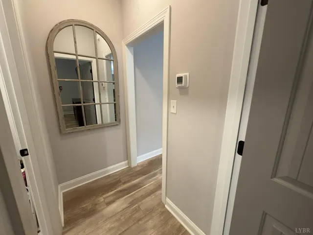 a view of a hallway with wooden floor and entryway