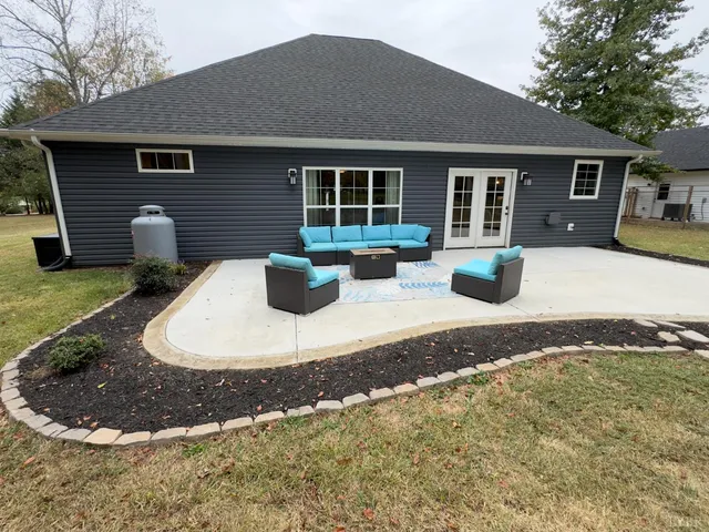 a view of a house with backyard and sitting area