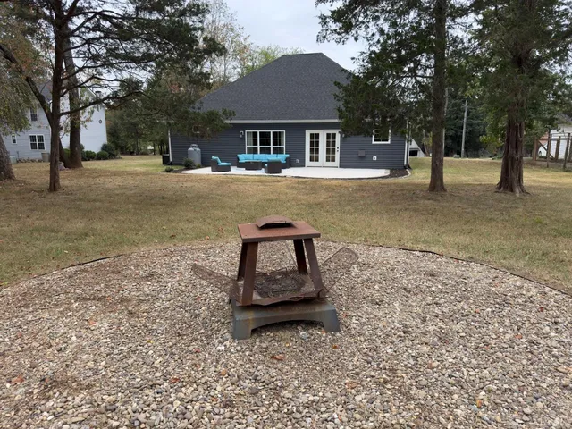 a backyard of a house with barbeque oven and table and chairs