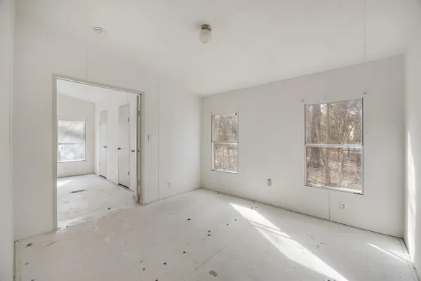 an empty room with windows and closet