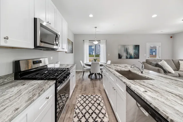 a kitchen with granite countertop stainless steel appliances and view living room