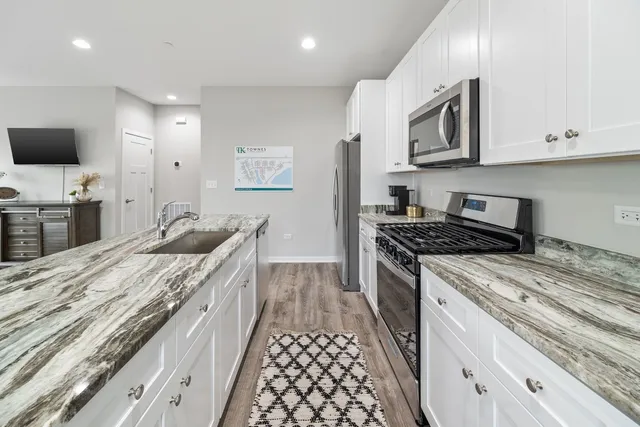 a kitchen with stainless steel appliances granite countertop a stove and a sink