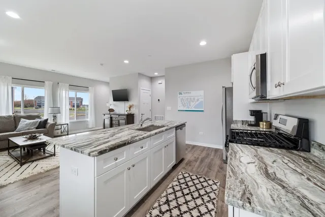 a kitchen with granite countertop a sink stove and cabinets
