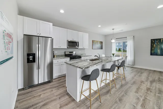 a kitchen with kitchen island granite countertop a sink cabinets and stainless steel appliances