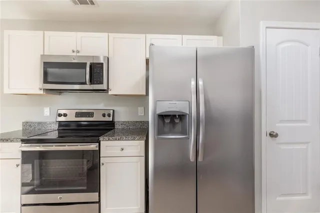 a kitchen with stainless steel appliances a refrigerator stove and microwave