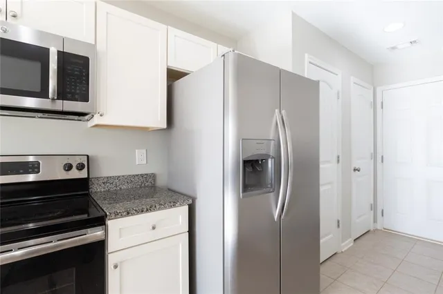 a kitchen with stainless steel appliances granite countertop a refrigerator and a stove top oven