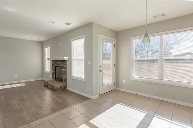 a view of empty room with a fireplace and windows