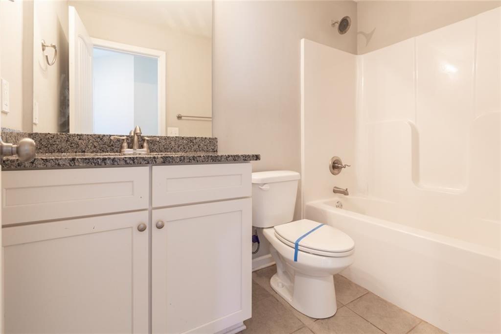 82 Gray Field Court Jefferson, GA 30549 - Photo 17 of 30 a bathroom with a granite countertop toilet a sink and a bathtub