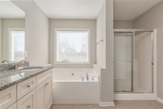 a bathroom with a granite countertop sink a mirror and a bathtub