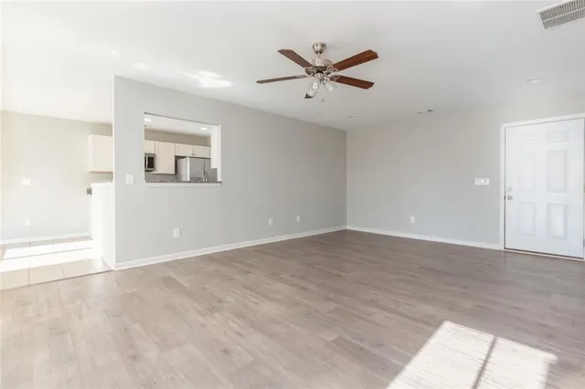 a view of a big room with wooden floor closet and windows