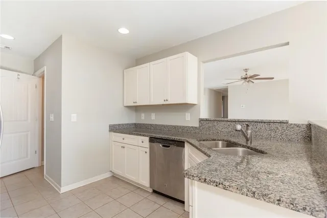 a kitchen with white cabinets granite counter tops and a sink
