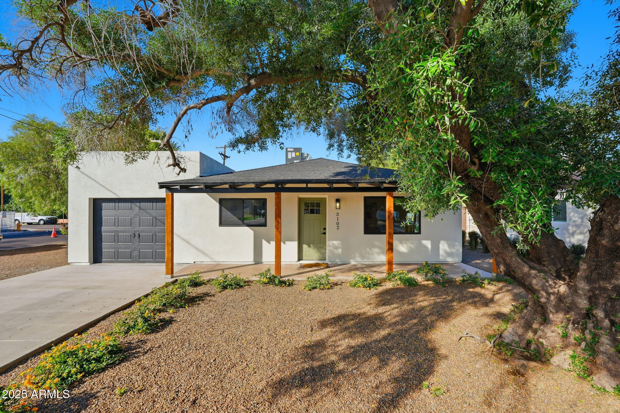 a view of a house with a yard and large tree