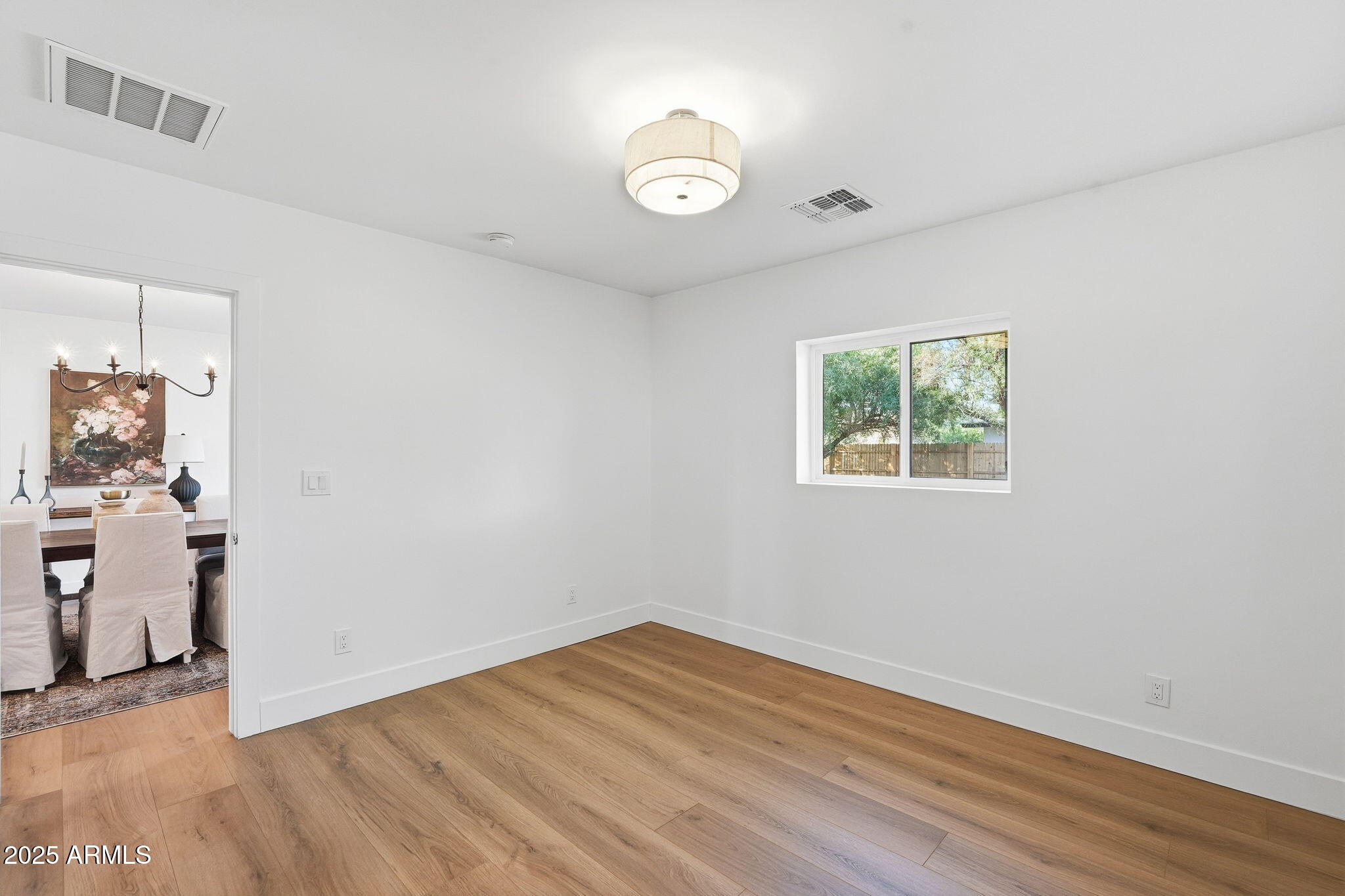 3102 North 34th Street Phoenix, AZ 85018 - Photo 11 of 20 an empty room with wooden floor and windows
