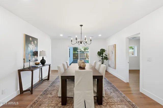 a dining room with furniture potted plants and wooden floor