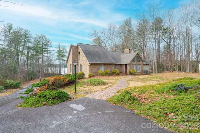 an empty room with wooden floor a fireplace and windows