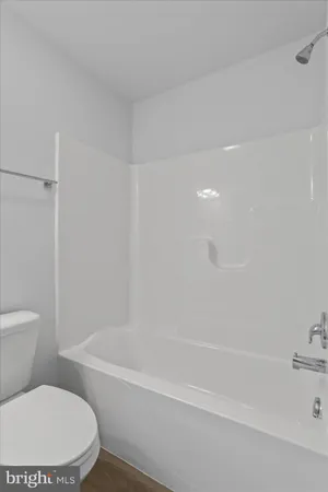 a white toilet and tub sitting next to a bathroom sink