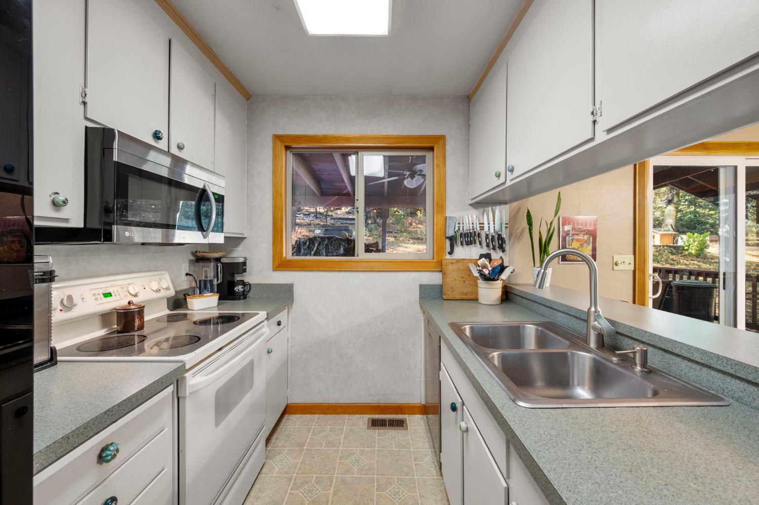 734 Utica Drive Murphys, CA 95247 - Photo 11 of 36 a kitchen that has a sink a stove and a microwave oven in it