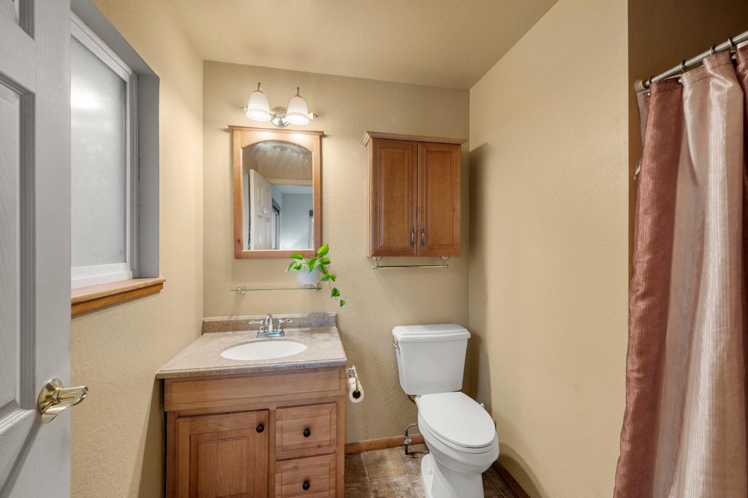 734 Utica Drive Murphys, CA 95247 - Photo 15 of 36 a bathroom with a toilet a sink and mirror
