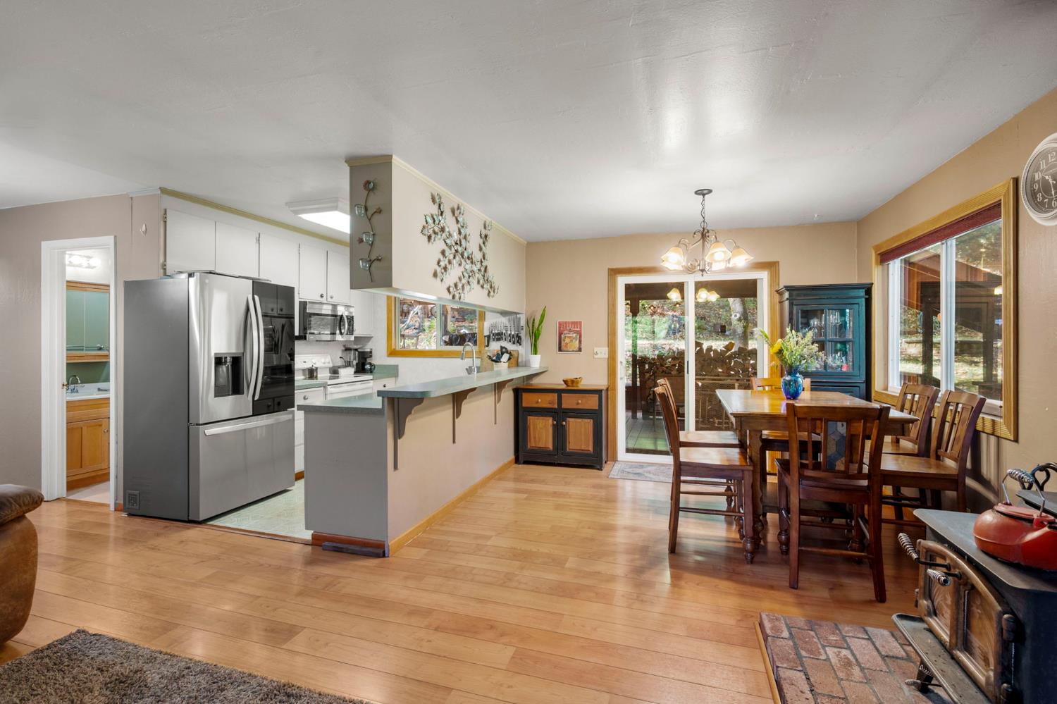 734 Utica Drive Murphys, CA 95247 - Photo 9 of 36 a kitchen with stainless steel appliances kitchen island granite countertop a refrigerator a stove a dining table and chairs with wooden floor