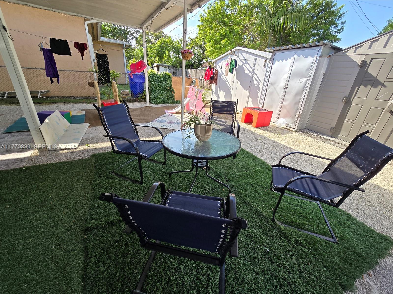1011 Northwest 64th Street Miami, FL 33150 - Photo 37 of 48 a view of a chairs and table in backyard