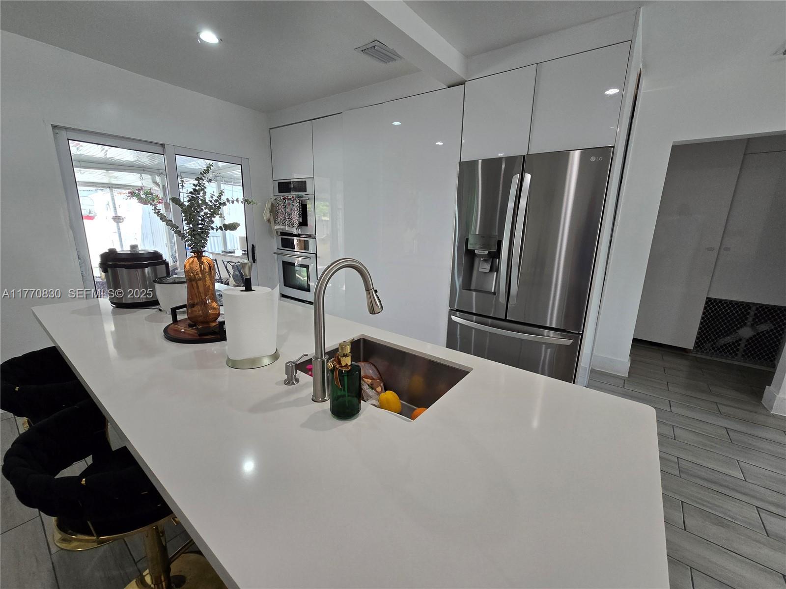 1011 Northwest 64th Street Miami, FL 33150 - Photo 9 of 48 a kitchen with refrigerator a sink and a cabinets