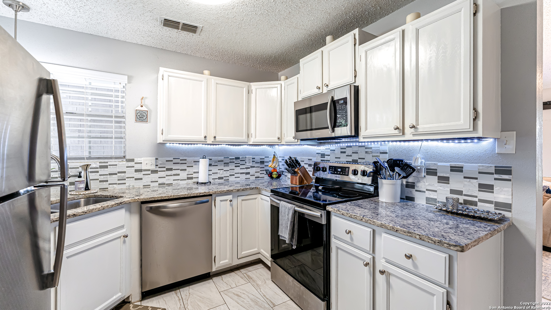 3309 Country View Schertz, TX 78108 - Photo 11 of 27 a kitchen with stainless steel appliances granite countertop a sink stove and cabinets