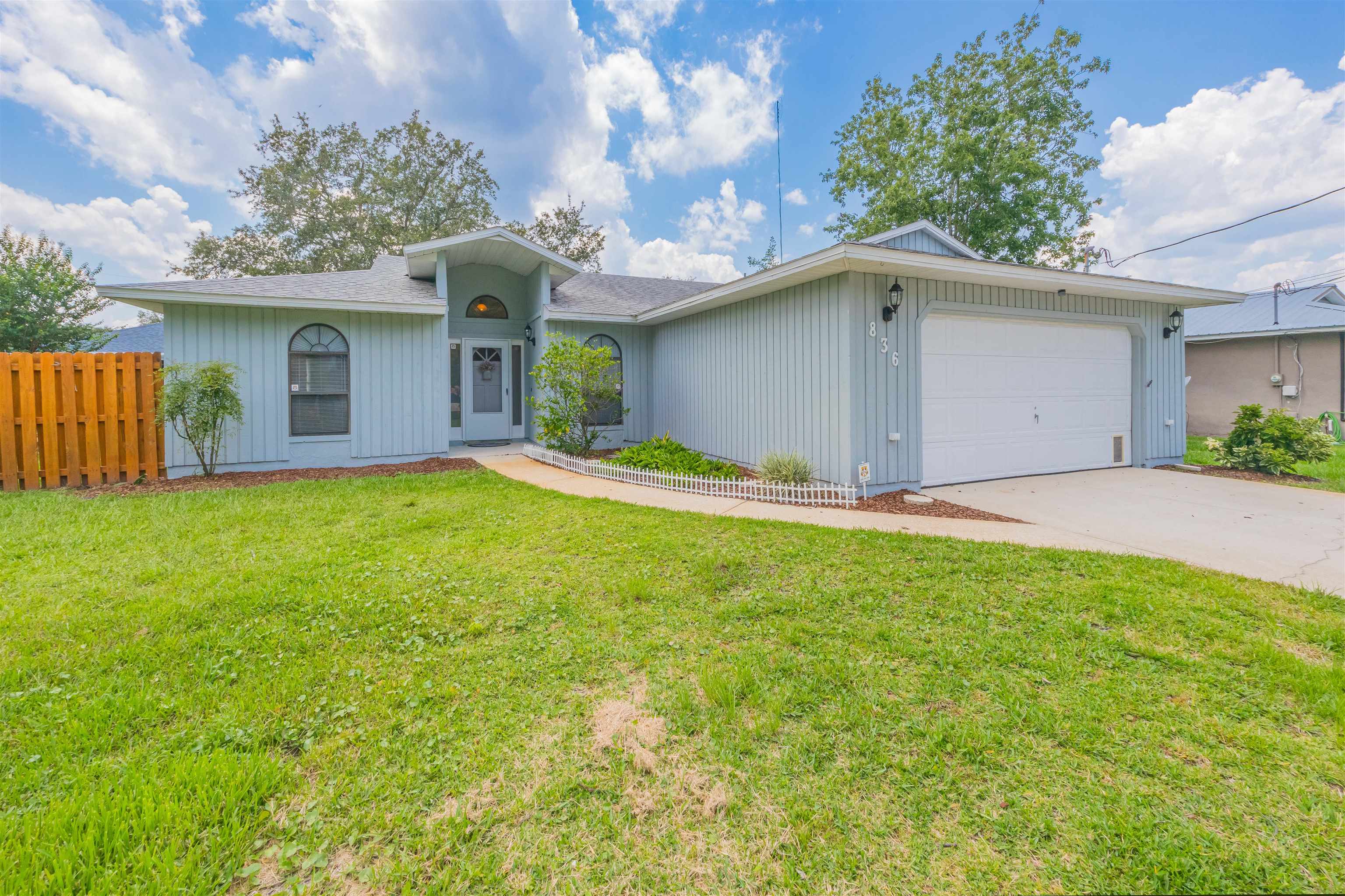836 Queen Road St. Augustine, FL 32086 - Photo 1 of 26 a view of a house with a yard and garage