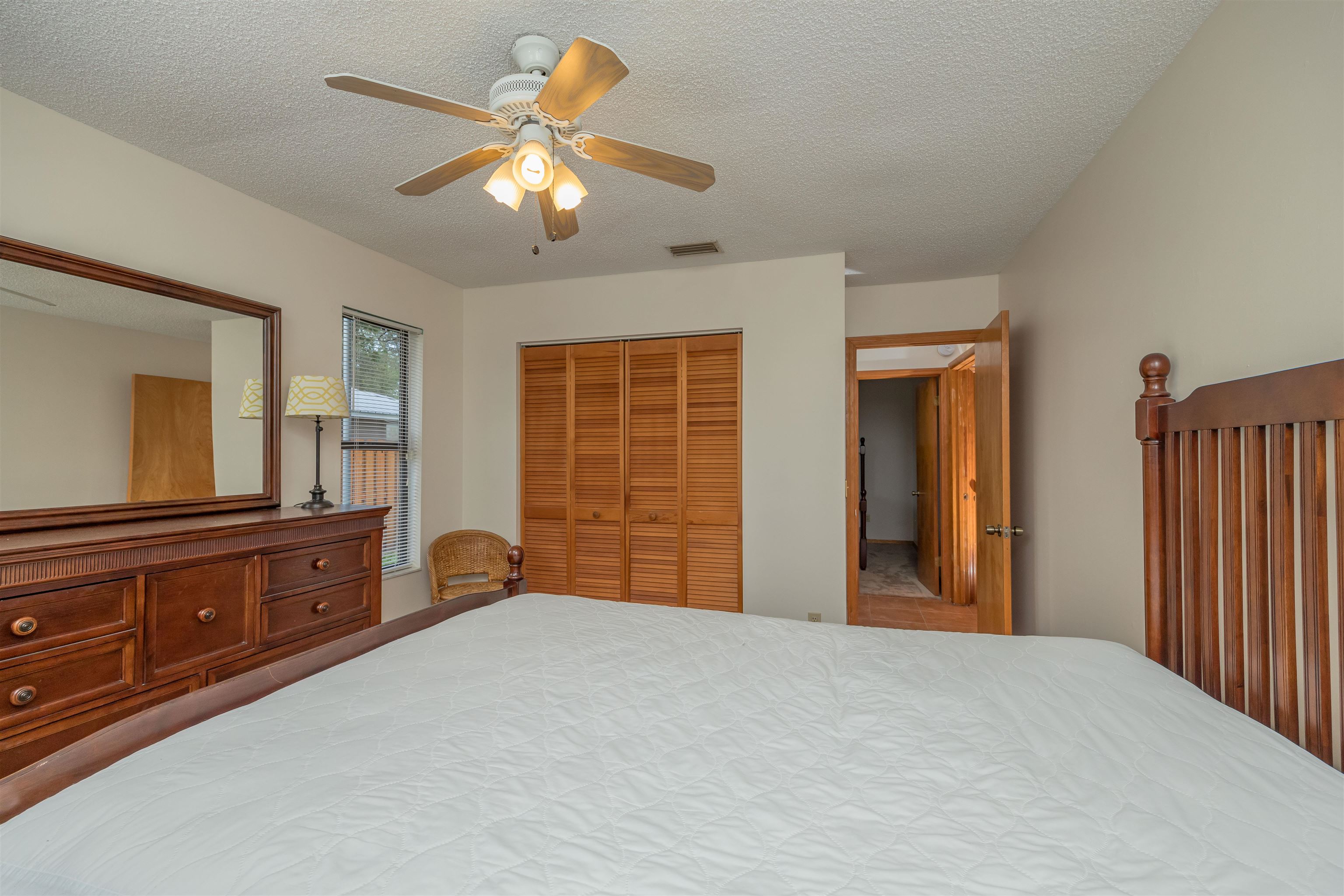 836 Queen Road St. Augustine, FL 32086 - Photo 23 of 26 a bedroom with a large bed and a chandelier