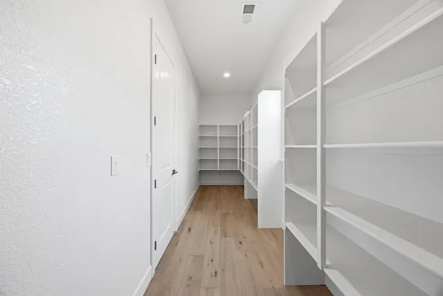 a view of walk in closet with wooden floor