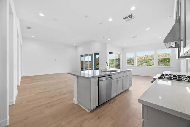 a kitchen with stainless steel appliances granite countertop a stove and a sink