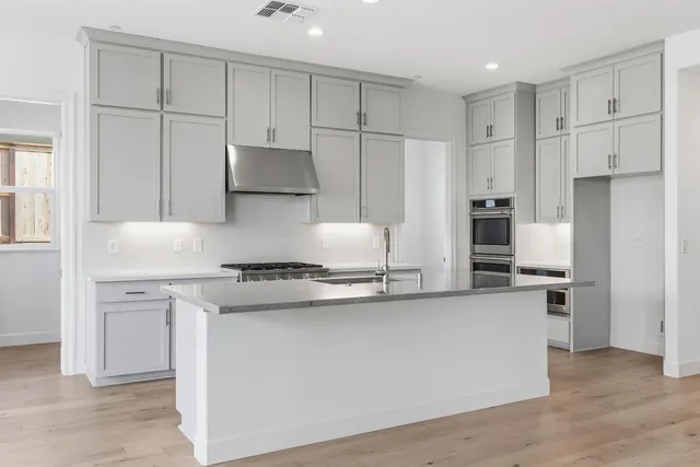 a kitchen with stainless steel appliances granite countertop a stove a refrigerator and a refrigerator