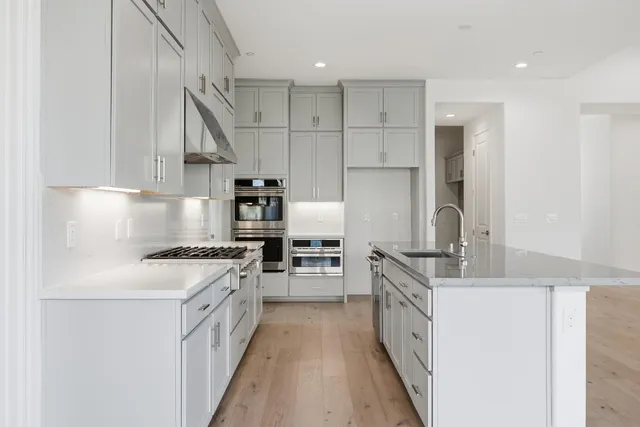 a kitchen with stainless steel appliances granite countertop a stove and a refrigerator