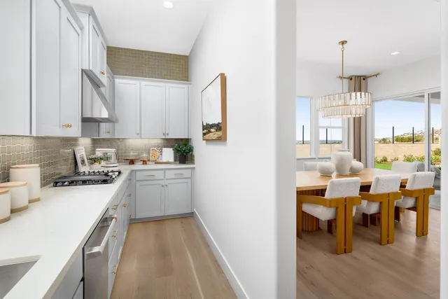 a kitchen with white cabinets and sink