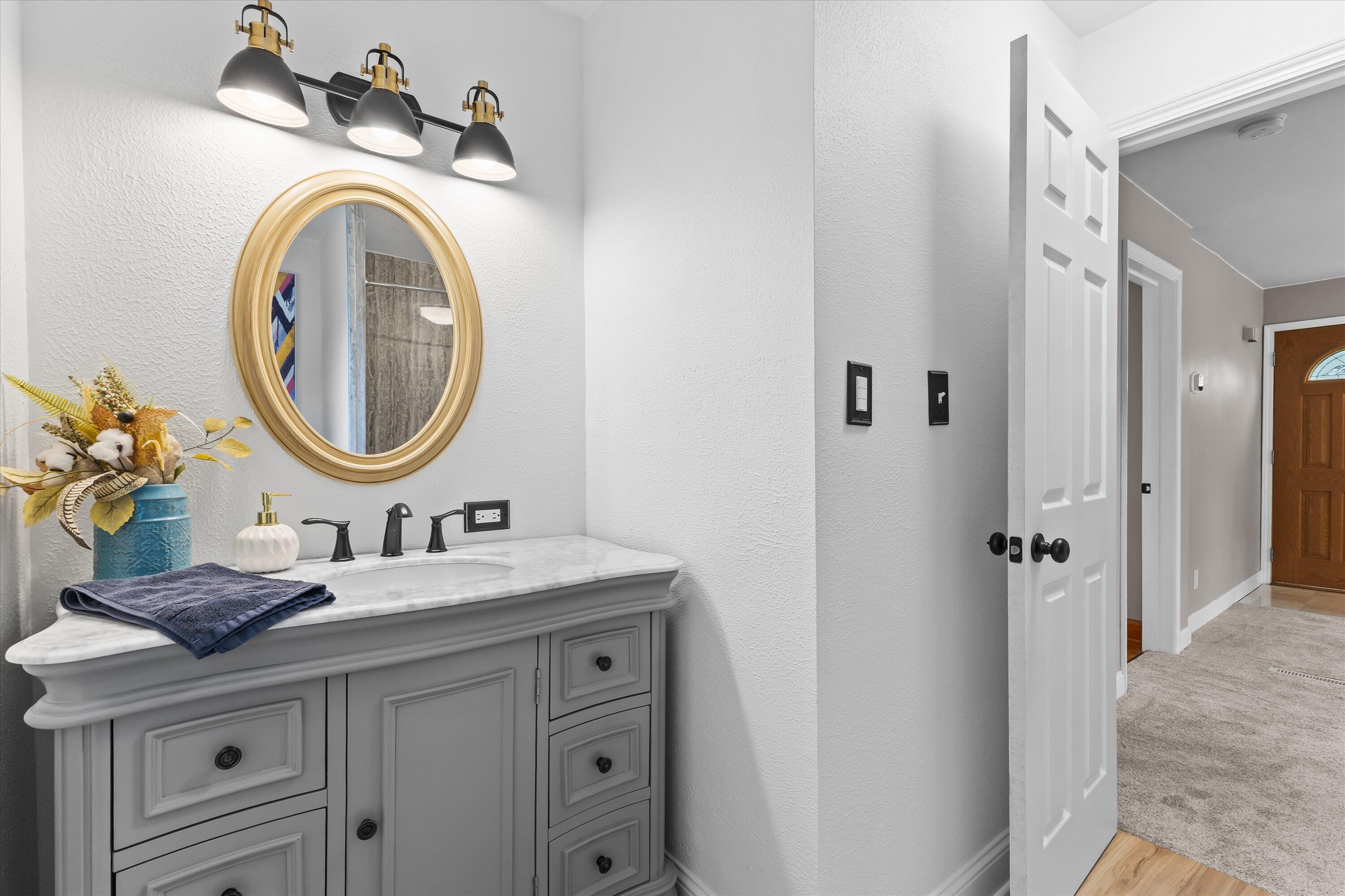 2925 North Main Street Racine, WI 53402 - Photo 7 of 23 A stylish vanity with marble countertop, designer lighting, and updated finishes create a bright, elegant space for guests and everyday living.