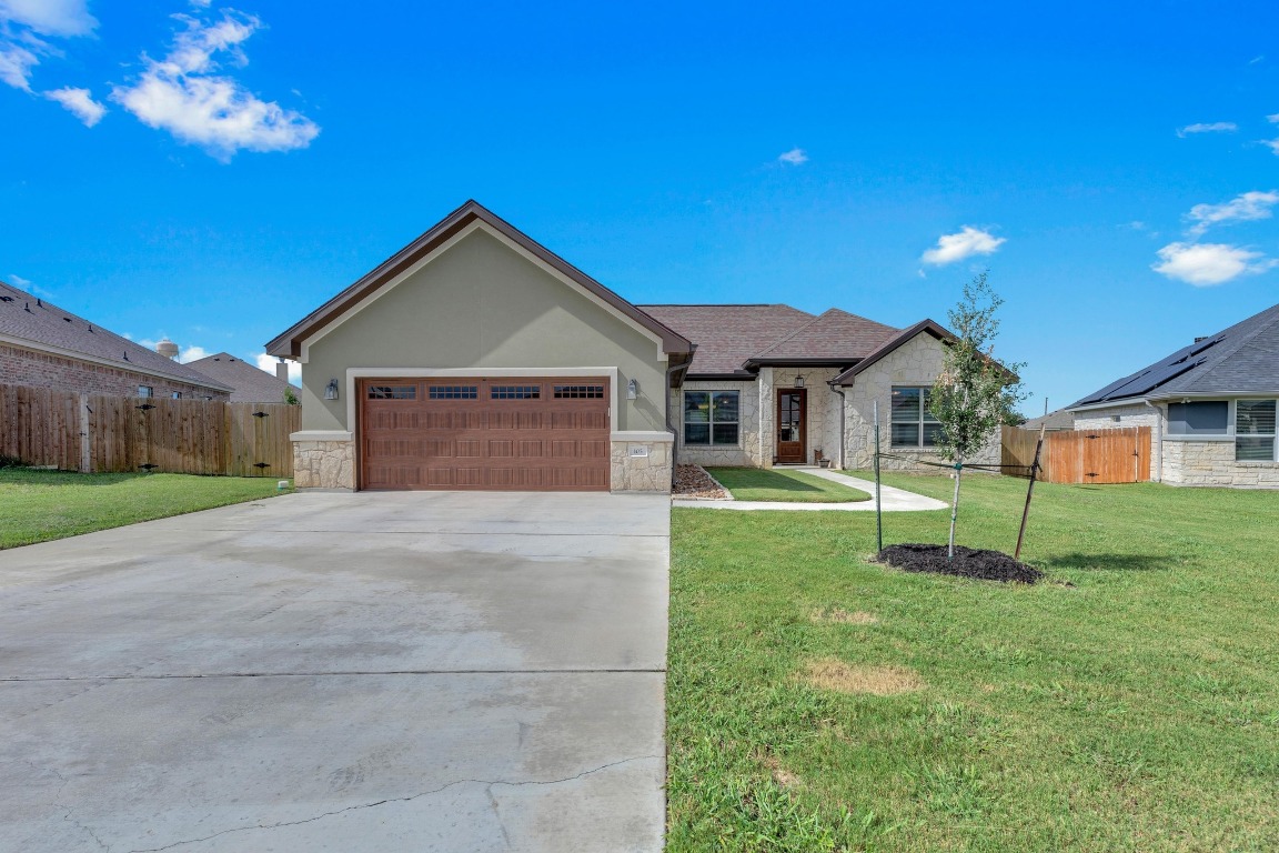 a front view of a house with a yard and garage