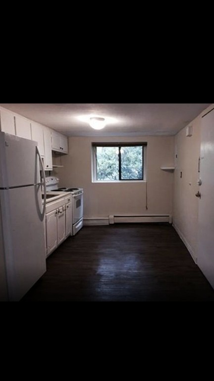 72 Bryon Road, Unit 1 Boston, MA 02467 - Photo 3 of 7 a kitchen with a refrigerator and wooden floor