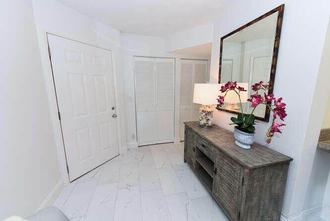 1605 Highway 1, Unit B105 Jupiter, FL 33477 - Photo 11 of 30 a hallway with beautiful frames and flower vase