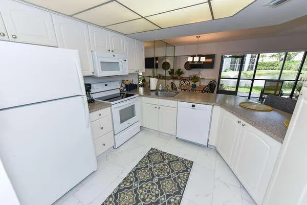 a kitchen with white cabinets and white appliances